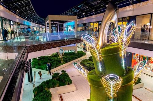 a shopping mall with a christmas tree in the middle at Détente & Jardin By Beds4Wanderlust - Charmant T2 avec Jardin - Gare Plaisir-Grignon, Versailles 20km in Plaisir
