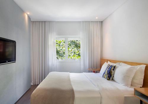 a bedroom with a white bed and white walls at Ipanema Inn Hotel in Rio de Janeiro