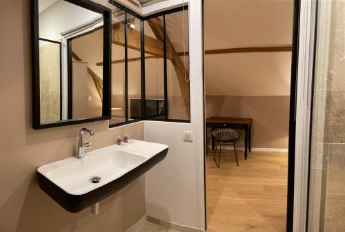 L'Atelier des Magnolias في Aumont: حمام مع حوض ومرآة