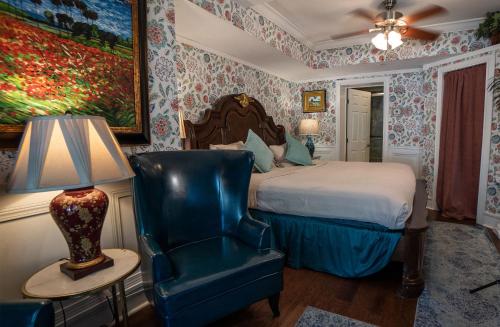 a bedroom with a bed and a chair and a lamp at Casablanca Inn on the Bay in Saint Augustine