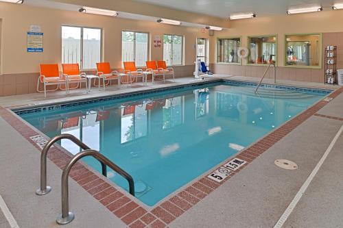 藍灰鎮的住宿－辛辛那提布魯艾什快捷假日酒店及套房，一座大型游泳池,里面设有橙色椅子