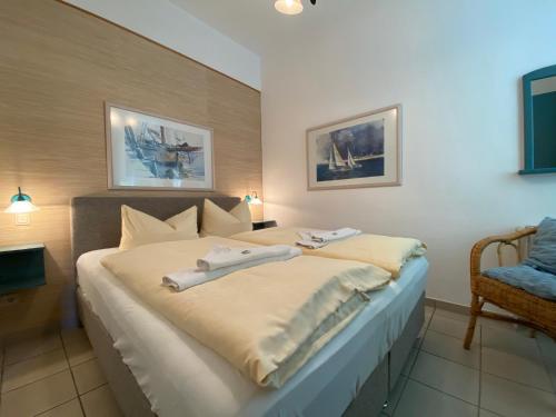 een slaapkamer met een bed met twee handdoeken erop bij Villa Caprivi - Ferienwohnung 7 in Heringsdorf