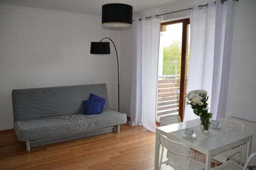 a living room with a couch and a table at Apartament Black & White Wczasowa in Ustka