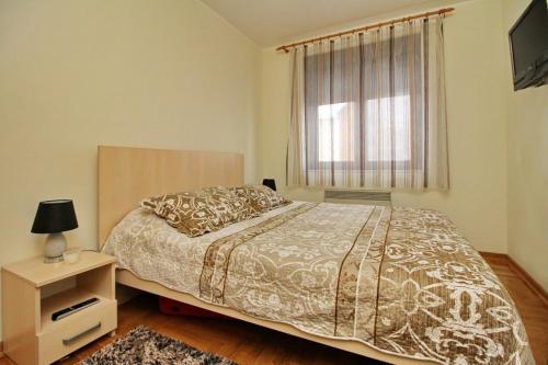 a bedroom with a large bed and a window at Apartment Adam-Zlatiborska Vila I in Zlatibor
