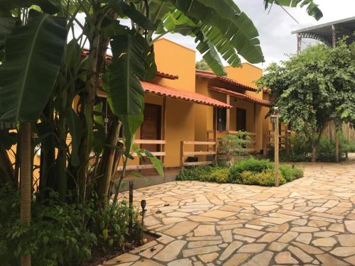 a house with a stone path in front of a building at Pousada Bougainville in Três Corações