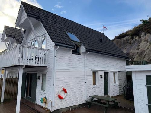 Casa blanca con balcón y mesa de picnic en 8 person holiday home in Urangsv g, en Steinsbø