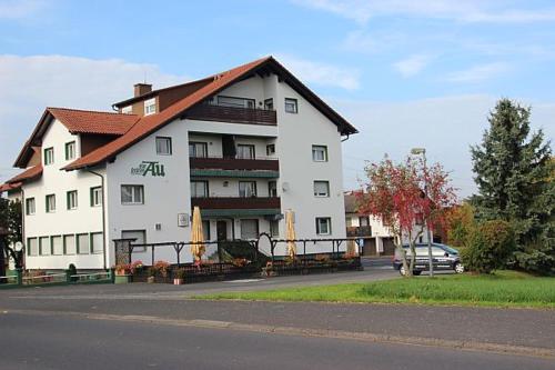 a large white building with a red roof at Grüne Au Hotel in Hasselroth