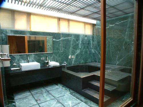 a bathroom with a tub and a sink and a mirror at Boutique Hot Spring Resort in Xindian