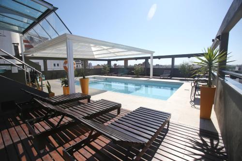 un patio con 2 sillas y una piscina en Hotel Bicentenario Suites & Spa en San Miguel de Tucumán