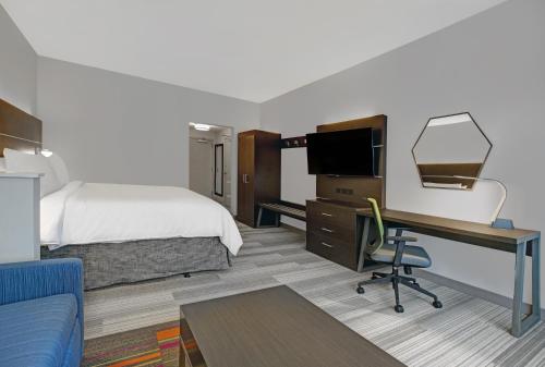 a hotel room with a bed and a desk with a computer at Holiday Inn Express - Milwaukee Downtown by IHG in Milwaukee
