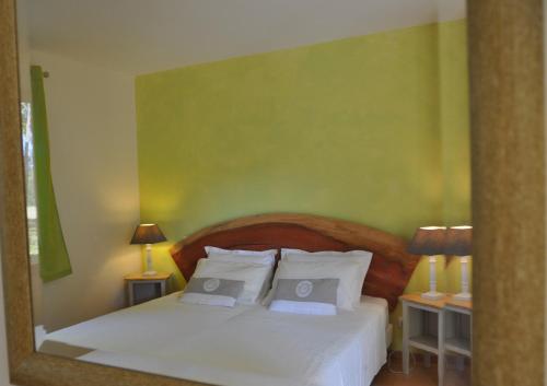 um quarto com uma cama branca e 2 almofadas em Les Pigeonnes em Groléjac