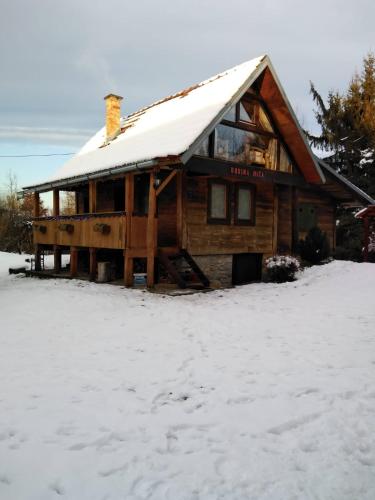 a log cabin with snow on the roof at Dorina hiža in Karlovac