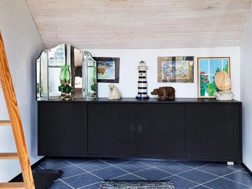a black cabinet in a room with some items on it at Seaside Serenity in LumsAYs-By Traum in Ebbeløkke