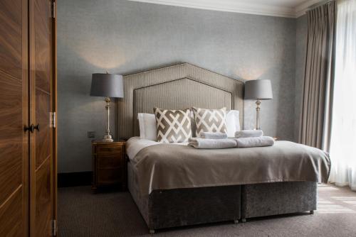 a bedroom with a large bed with two lamps on it at Kinnettles Hotel & Spa in St. Andrews