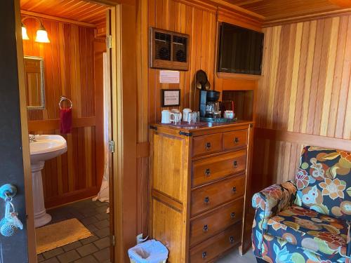 林肯市的住宿－Whistling Winds Motel，一间位于客房内的带梳妆台和椅子的浴室