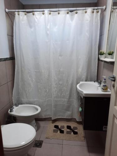 a bathroom with a toilet and a shower curtain at La Isabel in San Pedro