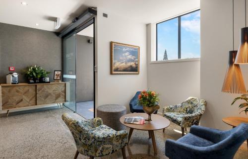 a waiting room with chairs and a table at 14th Lane Urban Hotel in Blenheim