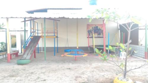 a play area with a slide and a playground at Casa Morada da Praia 1 in Peroba