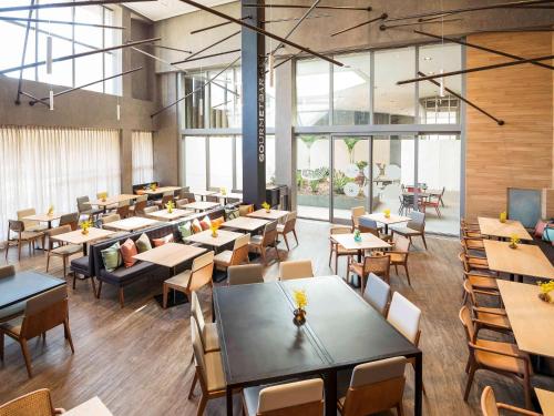a dining room with tables and chairs and windows at Novotel São Paulo Berrini in Sao Paulo