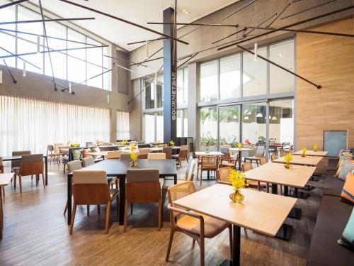 a restaurant with tables and chairs and windows at Novotel São Paulo Berrini in Sao Paulo