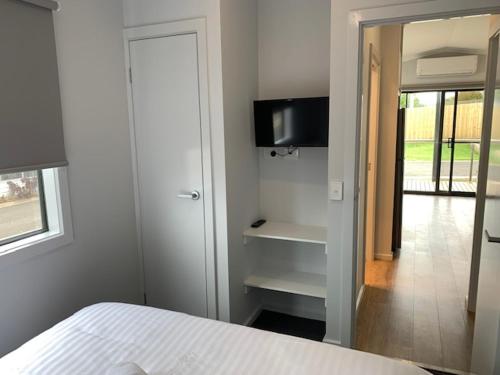 a bedroom with a bed and a tv on a wall at Portland Holiday Village in Portland