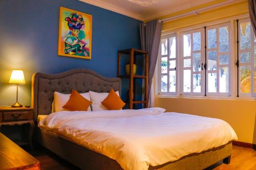 sypialnia z dużym łóżkiem z niebieskimi ścianami w obiekcie Crazy House w mieście Da Lat