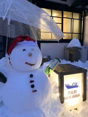 a snowman with an umbrella next to a box at B&B MIKAWA - Kanazawa Fish Harbour in Mikawa
