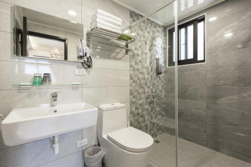 馬公市的住宿－52菊島旅店，浴室配有卫生间、盥洗盆和淋浴。
