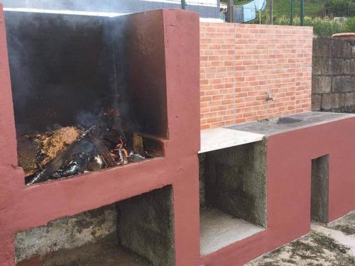 Un horno de ladrillo con fuego. en Casa do Avô Silva en Santa Cruz das Flores