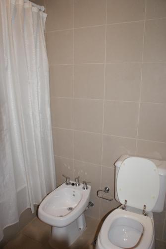 a bathroom with a toilet and a sink at El Puente Aparts- Departamentos Independientes in El Calafate