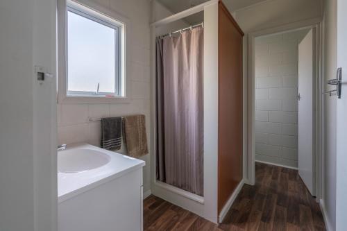 a bathroom with a sink and a shower with a window at Sierra Beachfront Motel in Kaikoura