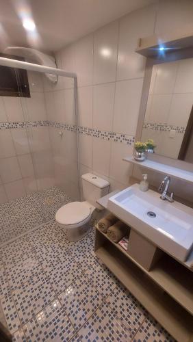 ein Bad mit einem WC und einem Waschbecken in der Unterkunft Pousada Kauai in Praia do Rosa