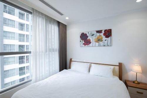 a bedroom with a bed and a large window at BOM HOMES- Vinhomes Times City- Service Apartment in Hanoi