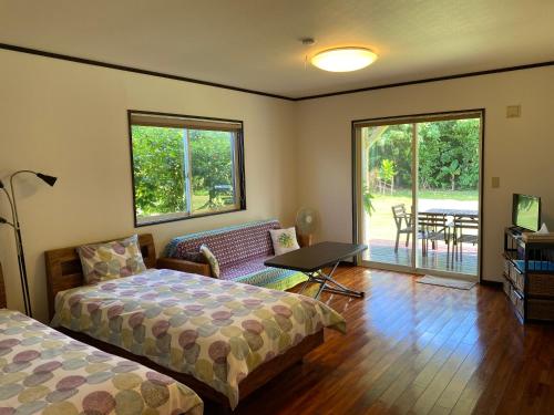 a bedroom with a bed and a couch and a table at guest house annsea in Ishigaki Island