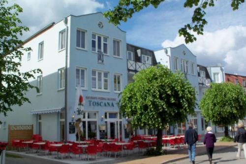 a group of buildings on a city street with red chairs at Haus Blaue Welle App 13 inkl Strandkorb in der HS in Bansin