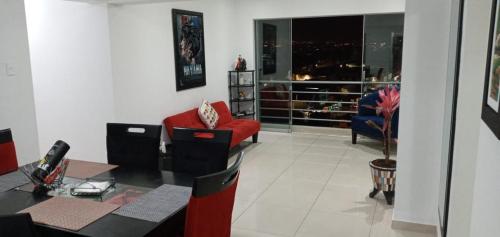 a living room with a red couch and a red chair at En el centro y hermosa vista! Con cochera in Trujillo