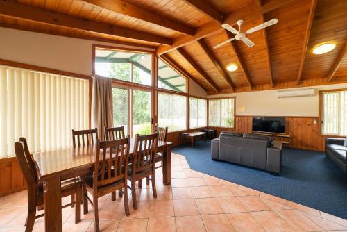 a dining room with a table and a couch at Halls Gap Valley Lodges in Halls Gap