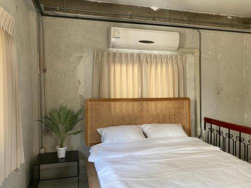 1 dormitorio con 1 cama con sábanas blancas y ventilador en EP1 shophouse en Bangkok
