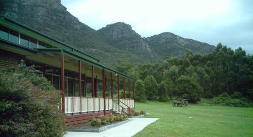 Ein Gebäude auf einem Feld mit Bergen im Hintergrund in der Unterkunft Halls Gap Valley Lodges in Halls Gap
