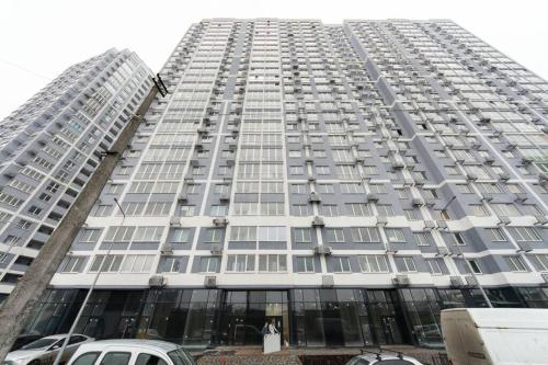 a large white building with a lot of windows at Современные апартаменты метро Харьковская генератор в доме in Kyiv