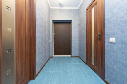 a hallway with a door and a blue floor at Современные апартаменты метро Харьковская генератор в доме in Kyiv
