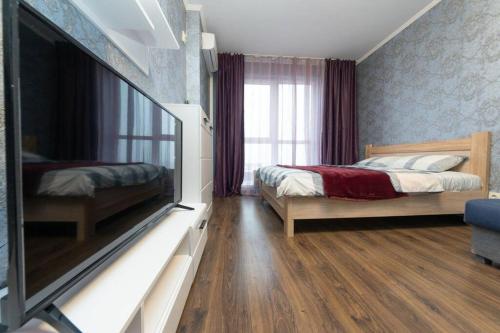 a bedroom with two beds and a flat screen tv at Современные апартаменты метро Харьковская генератор в доме in Kyiv