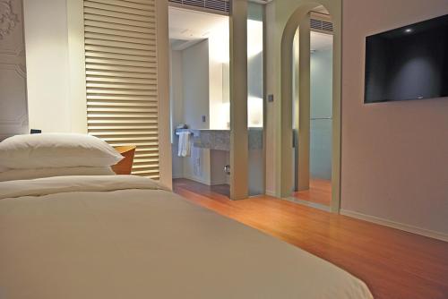 a bedroom with a white bed and a flat screen tv at Hotel Park Habio in Seoul