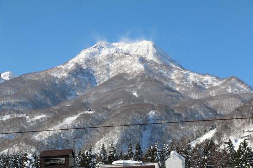 a snow covered mountain in front of a ski slope at The Address Akakura in Myoko