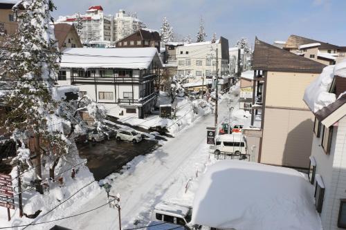 a city street covered in snow with buildings at The Address Akakura in Myoko