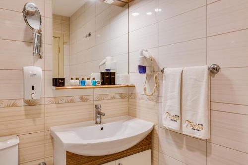 a bathroom with a white sink and a mirror at Twins Hotel in Ankara
