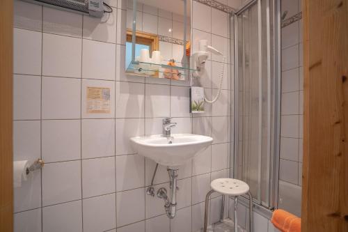 a white bathroom with a sink and a shower at Landhotel Weißer Hahn in Wemding