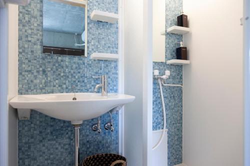 een badkamer met een wastafel, een spiegel en een douche bij Kokusai Street Garden Hotel -SEVEN Hotels and Resorts- in Naha