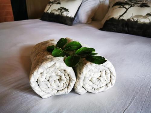 a pile of towels on top of a bed at Little Africa Safari Lodge in Hoedspruit