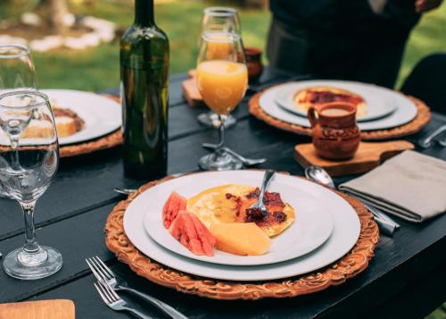 una tavola con piatti di cibo e bicchieri di vino di Boscoso Hotel Boutique a Valle de Bravo